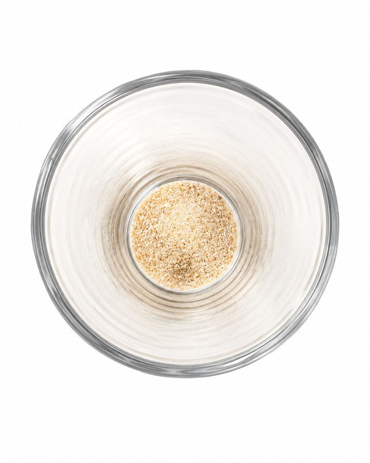 Looking down into a glass with NRF2 powder in the bottom